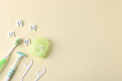 Photo of Different oral care products and teeth models on beige background, flat lay. Space for text