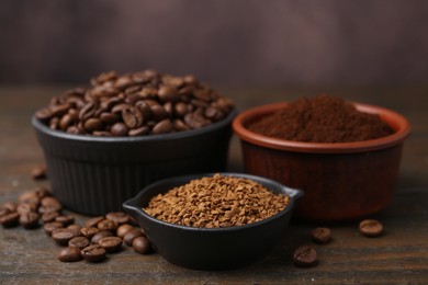 Photo of Different types of instant coffee and beans in bowls on wooden table against brown background, closeup