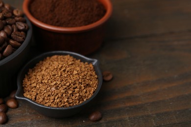 Photo of Different types of instant coffee and beans in bowls on wooden table, closeup. Space for text