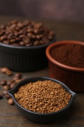 Photo of Different types of instant coffee and beans in bowls on wooden table against brown background, closeup