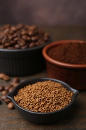 Photo of Different types of instant coffee and beans in bowls on wooden table against brown background, closeup