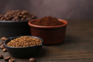 Photo of Different types of instant coffee and beans in bowls on wooden table against brown background, closeup