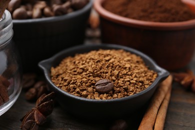 Photo of Instant (granulated) coffee, bean and spices on wooden table, closeup