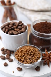 Photo of Different types of instant coffee, beans and spices on table, closeup