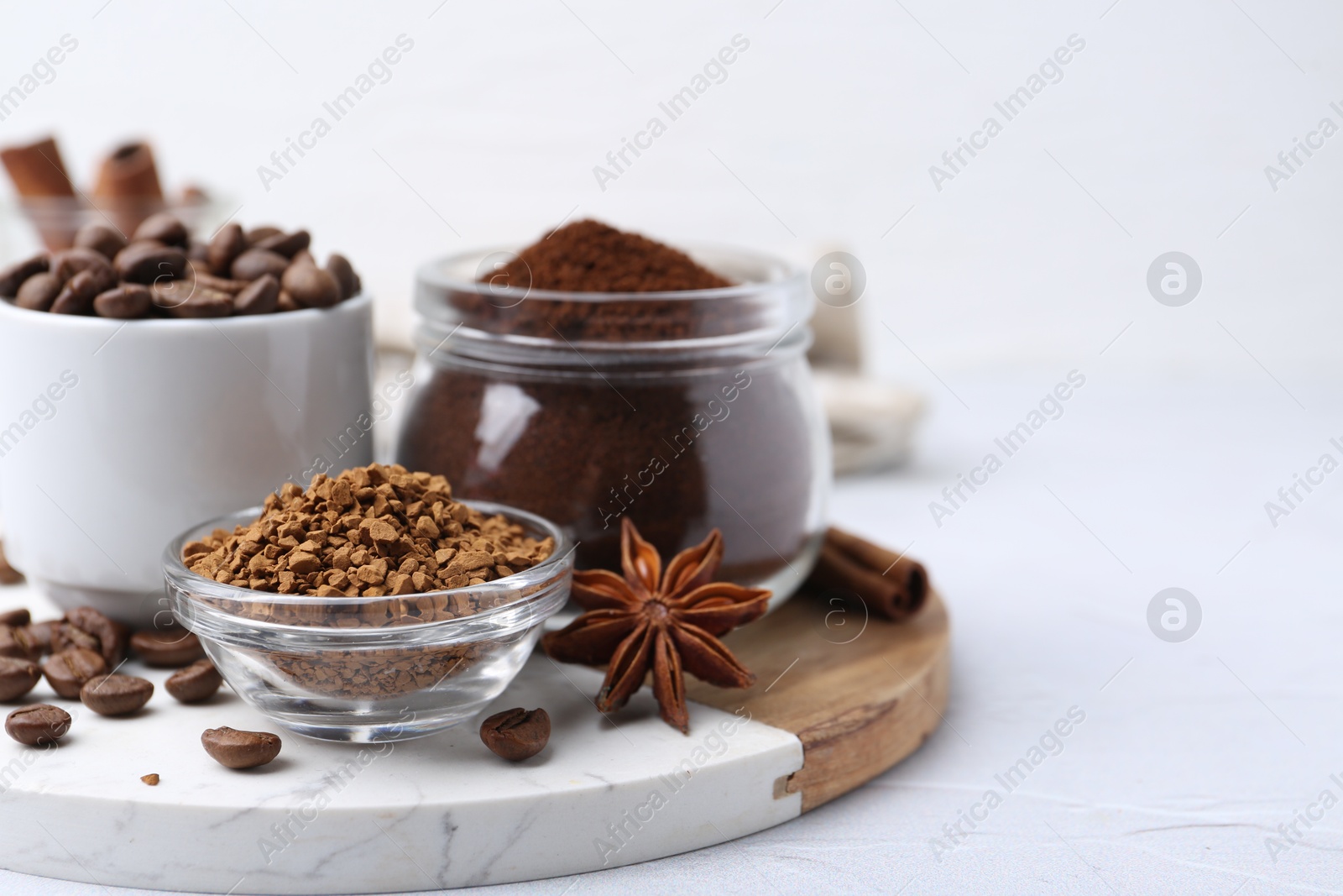 Photo of Different types of instant coffee, beans and spices on light textured table, closeup. Space for text