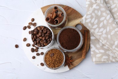Photo of Different types of instant coffee, beans and spices on light textured table, top view