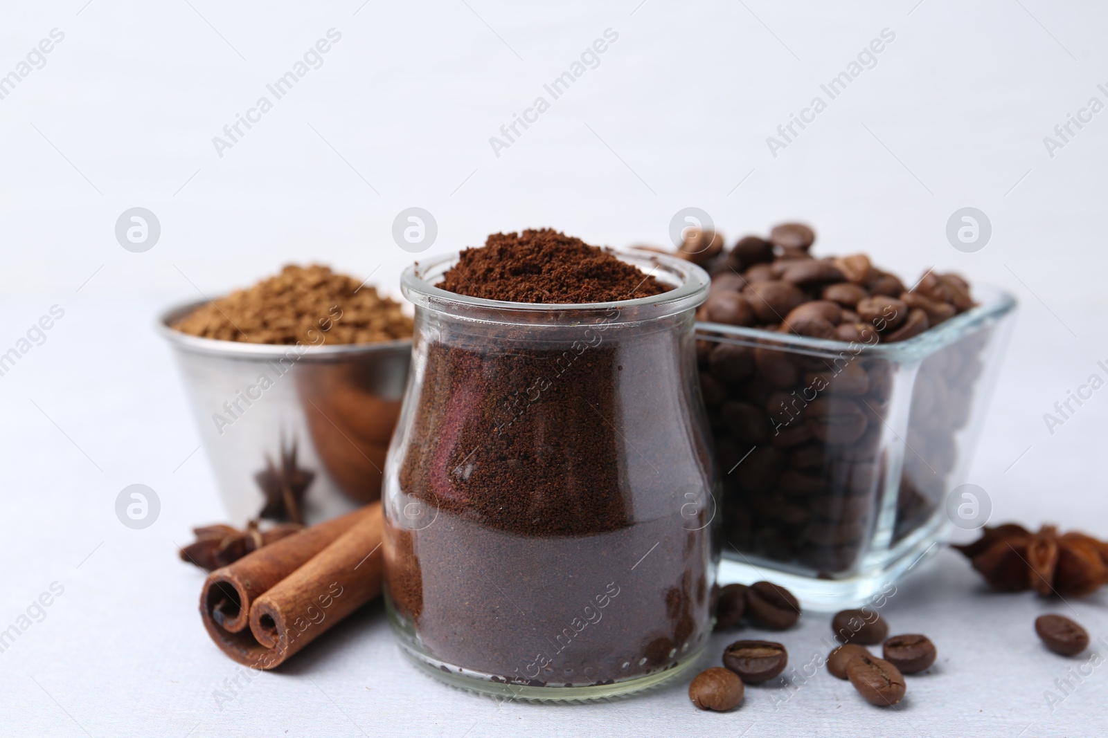 Different types of instant coffee, beans and spices on light table, closeup Photo of Different types of instant coffee, beans and spices on light table, closeup