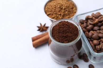 Photo of Different types of instant coffee, beans and spices on light table, closeup. Space for text