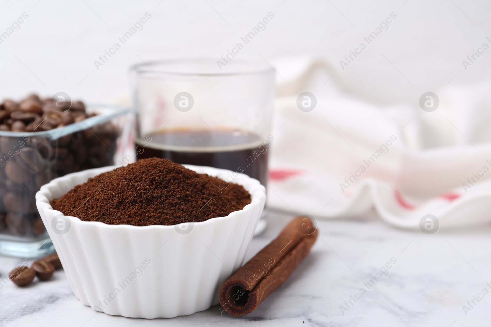 Instant coffee powder in bowl, cinnamon stick, beans and drink on white marble table, closeup. Space for text Photo of Instant coffee powder in bowl, cinnamon stick, beans and drink on white marble table, closeup. Space for text