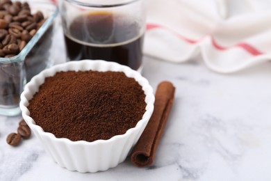 Photo of Instant coffee powder in bowl, cinnamon stick, beans and drink on white marble table, closeup. Space for text