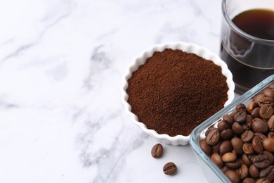 Photo of Instant coffee powder, beans and drink on white marble table, closeup. Space for text