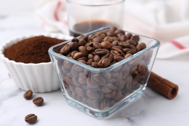 Photo of Roasted beans and instant coffee powder on white marble table, closeup