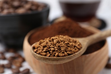 Photo of Granulated instant coffee in spoon and bowl on light table, selective focus