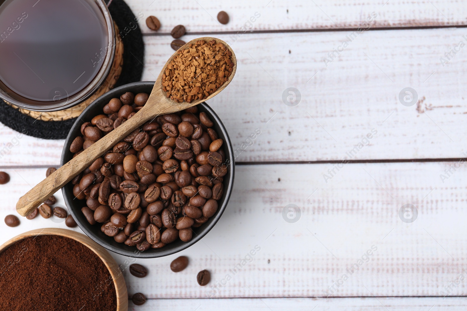 Different types of instant coffee, beans and aromatic drink on light wooden table, flat lay. Space for text Photo of Different types of instant coffee, beans and aromatic drink on light wooden table, flat lay. Space for text