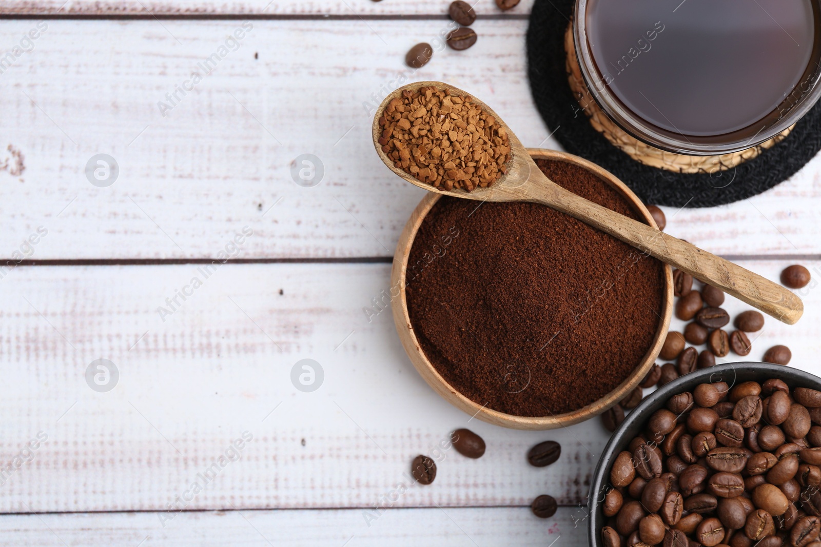 Different types of instant coffee, beans and aromatic drink on light wooden table, flat lay. Space for text Photo of Different types of instant coffee, beans and aromatic drink on light wooden table, flat lay. Space for text