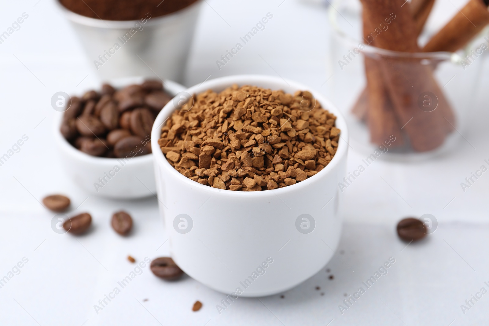Granulated instant coffee and beans on light table, closeup Photo of Granulated instant coffee and beans on light table, closeup