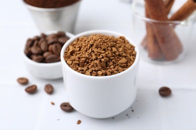 Photo of Granulated instant coffee and beans on light table, closeup