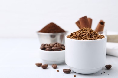 Photo of Granulated instant coffee and beans on light table, selective focus. Space for text