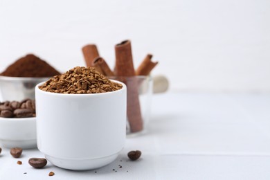 Photo of Granulated instant coffee and beans on light table, selective focus. Space for text