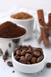 Photo of Roasted beans, different types of instant coffee and cinnamon sticks on light table, closeup