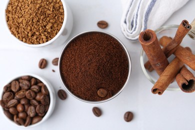 Photo of Different types of instant coffee, beans and cinnamon sticks on light table, flat lay