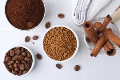 Photo of Different types of instant coffee, beans and cinnamon sticks on light table, flat lay