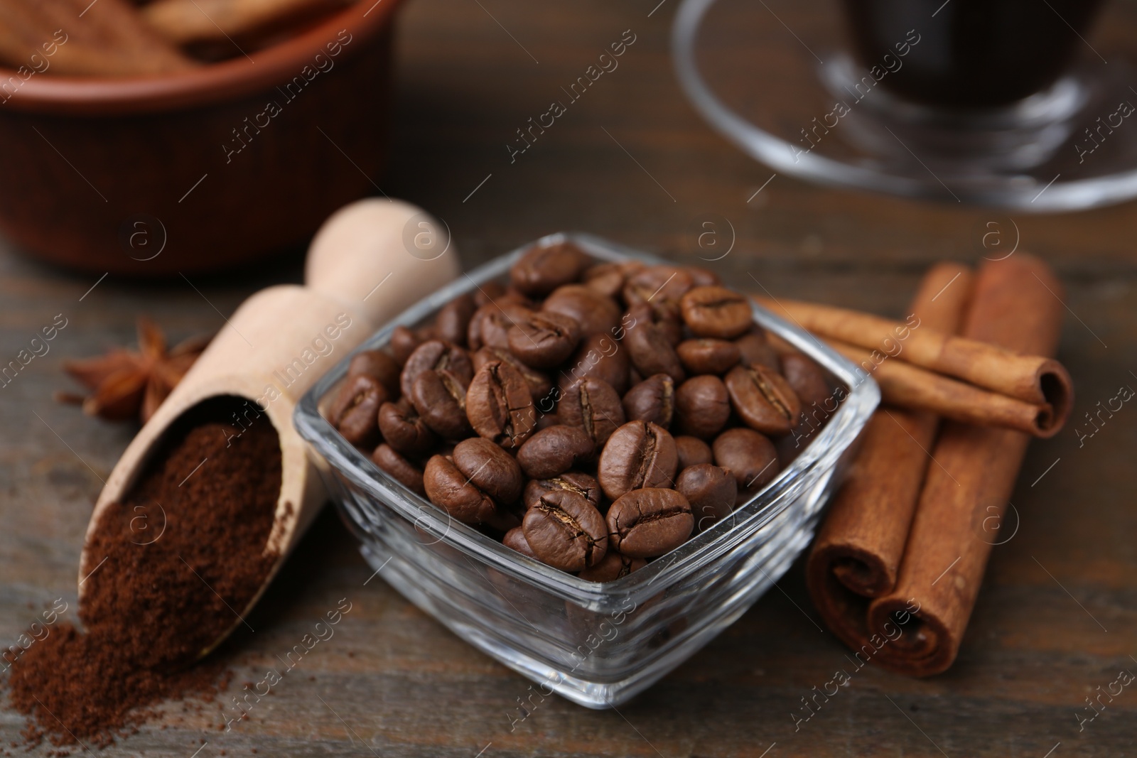Roasted beans, instant coffee powder and cinnamon sticks on wooden table, closeup Photo of Roasted beans, instant coffee powder and cinnamon sticks on wooden table, closeup