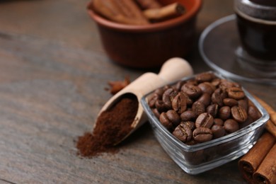 Photo of Roasted beans, instant coffee powder and cinnamon sticks on wooden table, closeup. Space for text