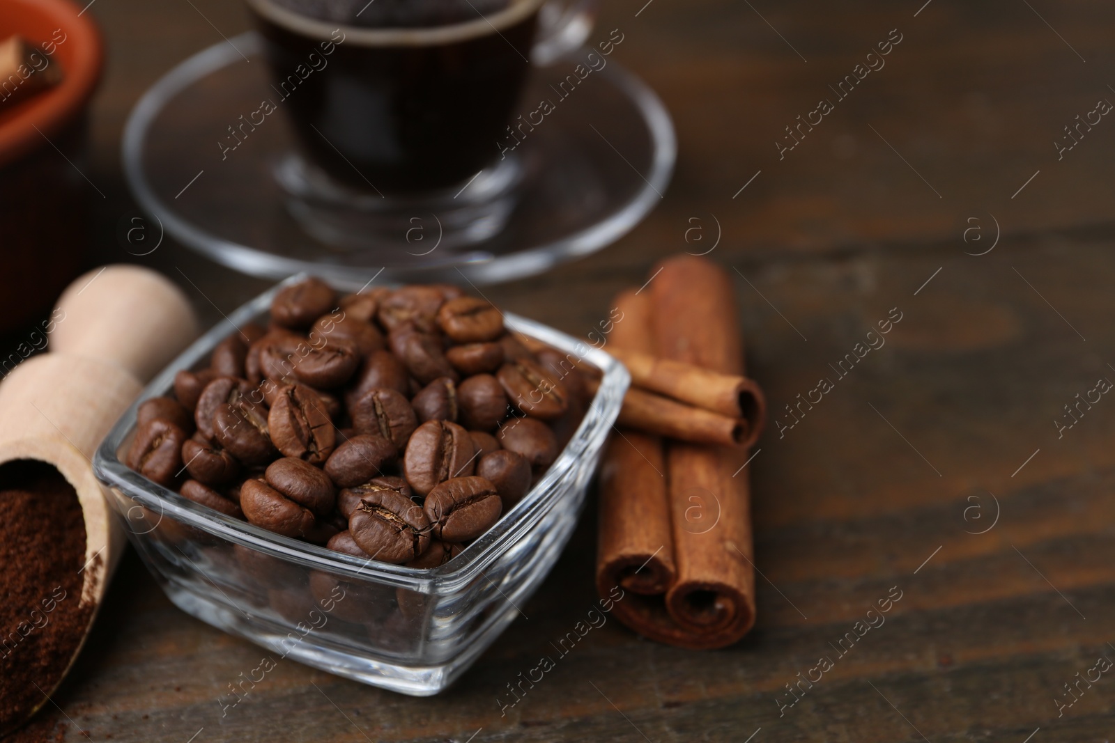 Roasted beans, instant coffee powder and cinnamon sticks on wooden table, closeup Photo of Roasted beans, instant coffee powder and cinnamon sticks on wooden table, closeup