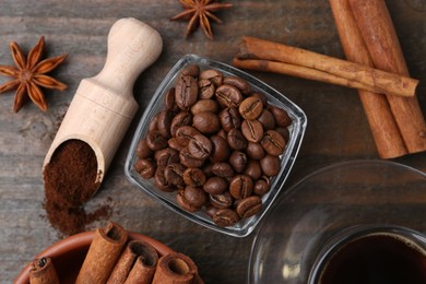 Photo of Roasted beans, instant coffee powder and spices on wooden table, flat lay