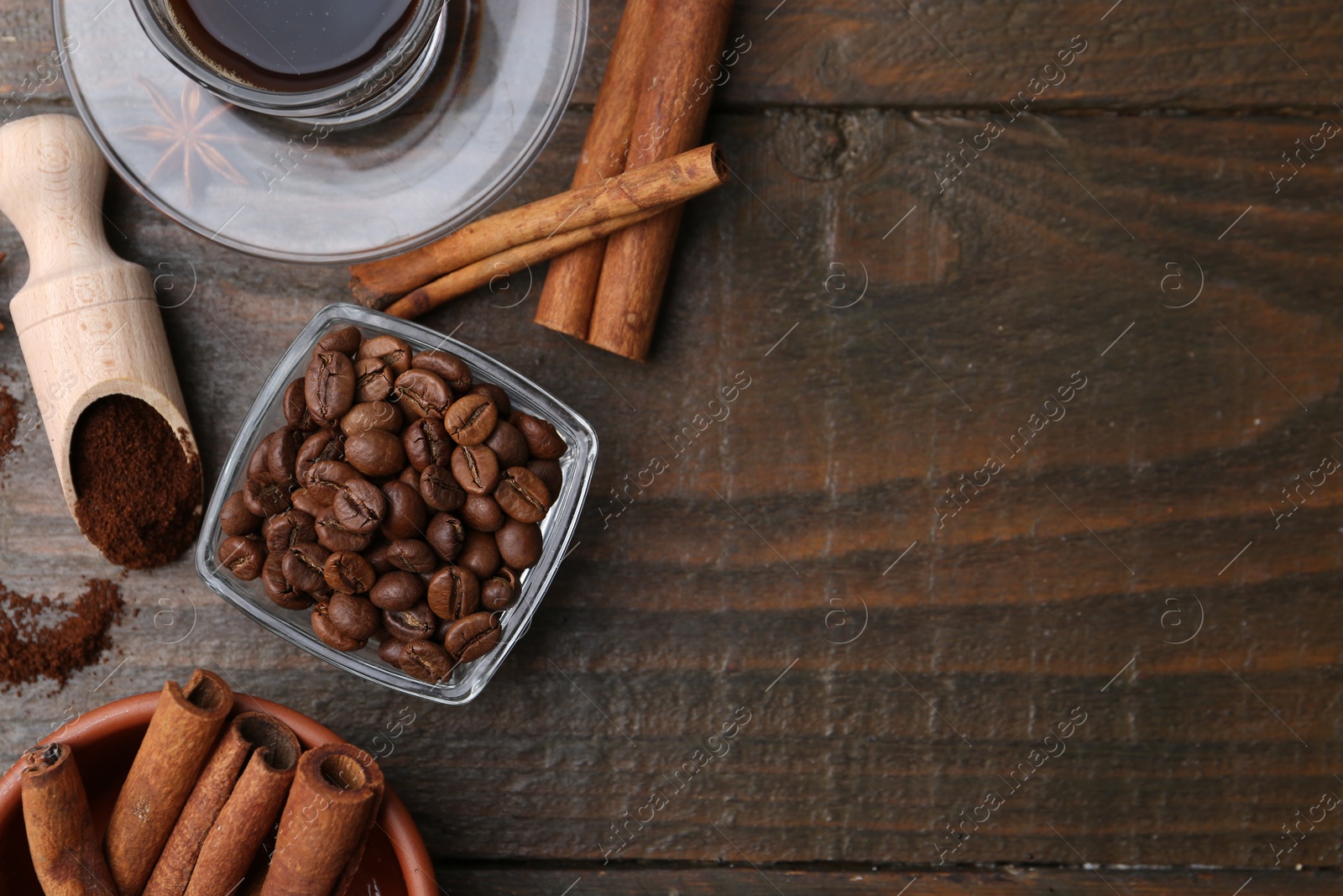 Roasted beans, instant coffee powder and cinnamon sticks on wooden table, flat lay. Space for text Photo of Roasted beans, instant coffee powder and cinnamon sticks on wooden table, flat lay. Space for text