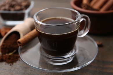 Photo of Refreshing coffee in cup on wooden table, closeup