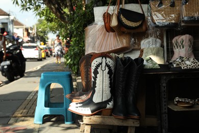 Photo of Bali, Indonesia - May 25, 2025: Different shoes and accessories on display at outdoor market