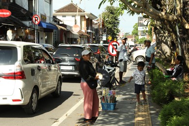 Photo of Bali, Indonesia - May 25, 2025: Crowded street with locals and cars