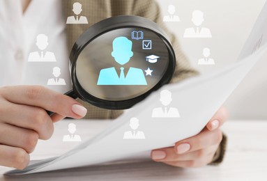 Image of Employee search. Woman looking at document through magnifier at table, closeup. Human icons as candidates