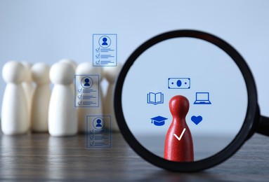 Image of Employee search. Red pawn among white ones on table, view through magnifying glass