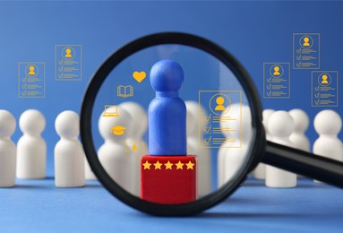 Image of Employee search. Blue pawn among white ones, view through magnifying glass