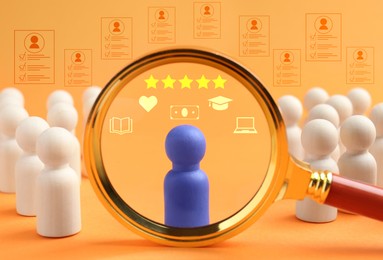 Image of Employee search. Blue pawn among white ones on orange background, view through magnifying glass