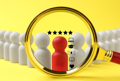 Image of Employee search. Red pawn among white ones on yellow background, view through magnifying glass
