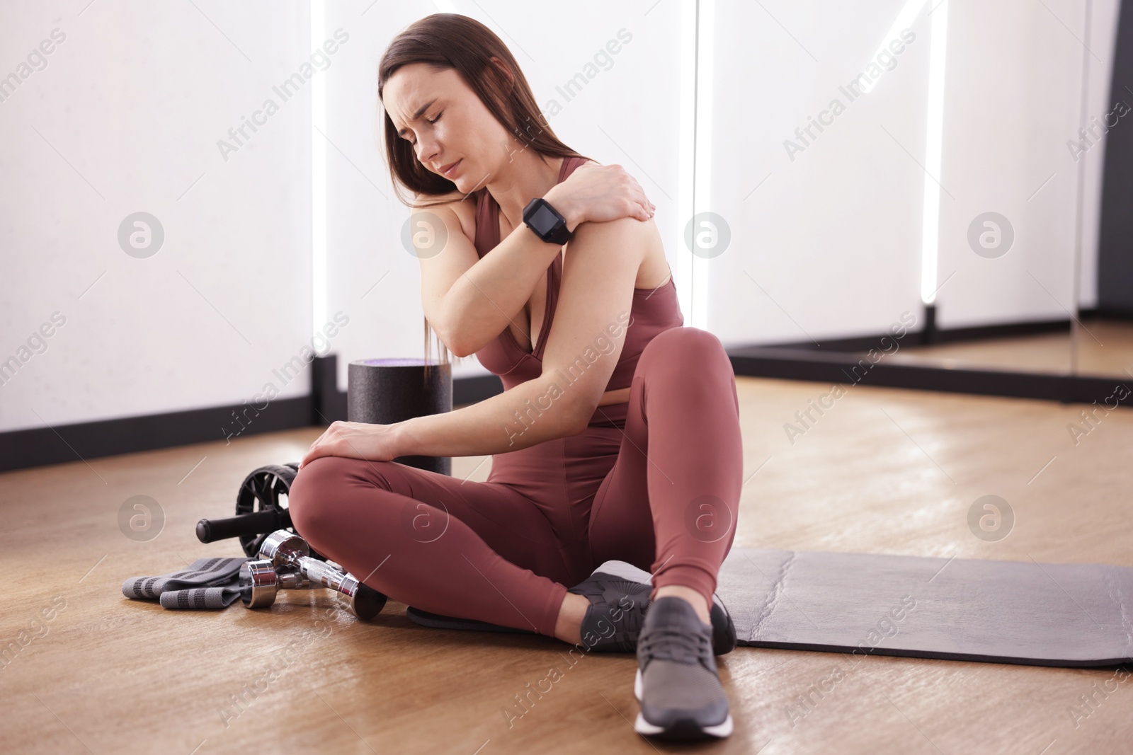 Sports injury. Woman with pain in shoulder indoors Photo of Sports injury. Woman with pain in shoulder indoors