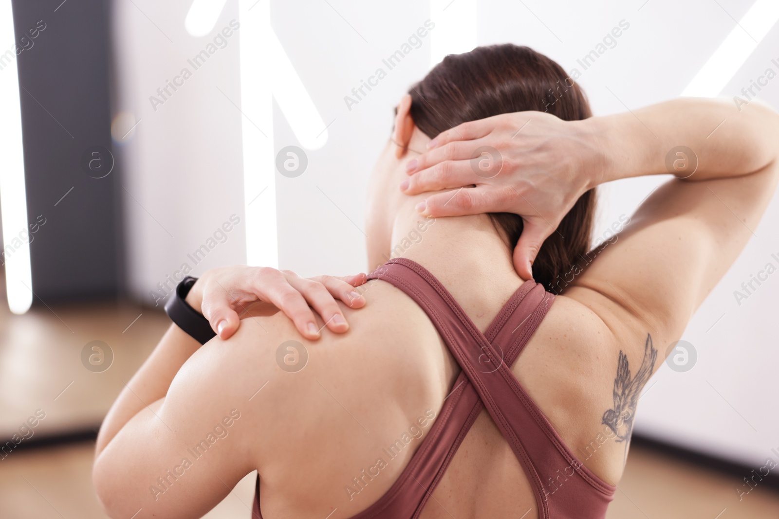 Sports injury. Woman with pain in shoulder indoors Photo of Sports injury. Woman with pain in shoulder indoors