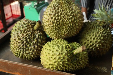 Photo of Fresh ripe durians on counter at market, closeup