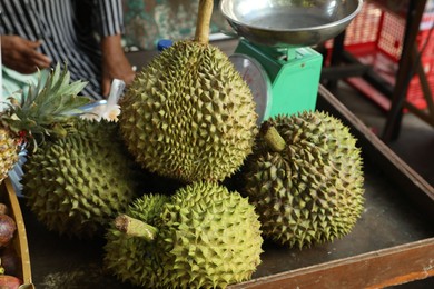 Photo of Fresh ripe durians on counter at market, closeup