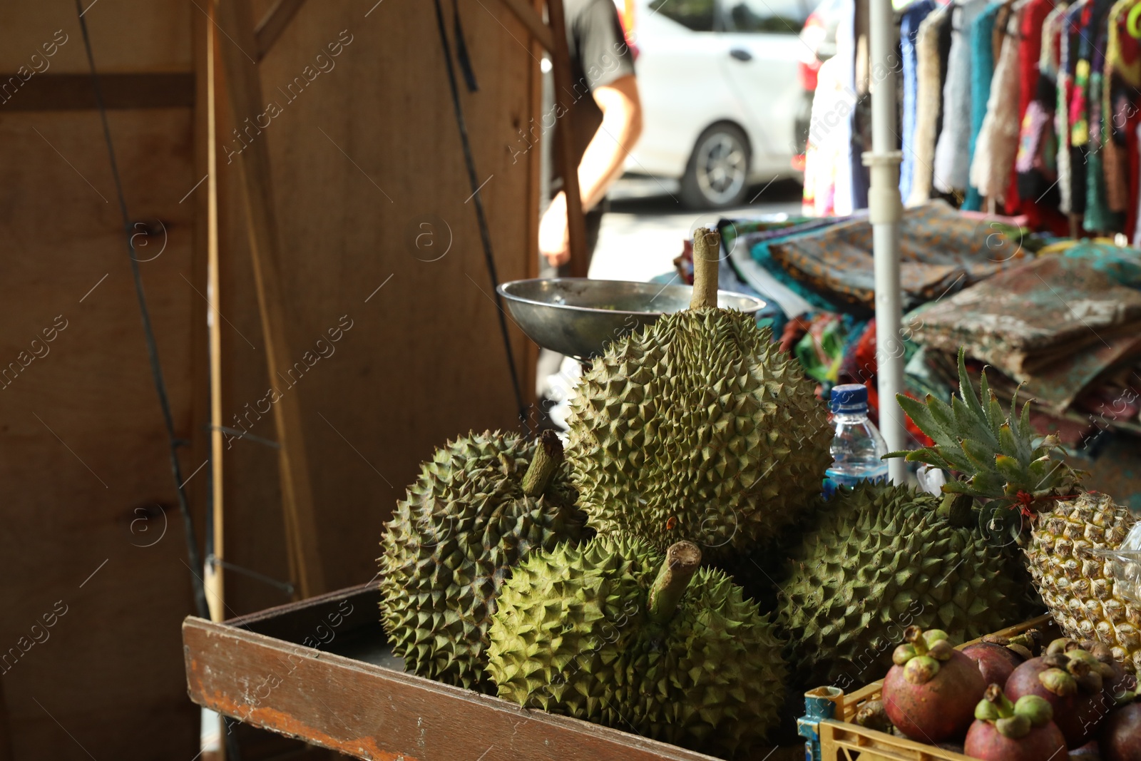 Photo of Fresh ripe durians and other different fruits at market, closeup