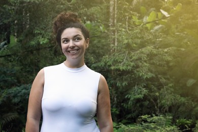 Photo of Happy woman in tropical forest, space text copy