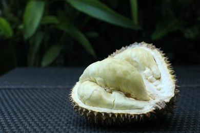 Photo of Fresh ripe durian on wicker table outdoors, closeup. Space for text