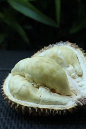Photo of Fresh ripe durian on wicker table outdoors, closeup