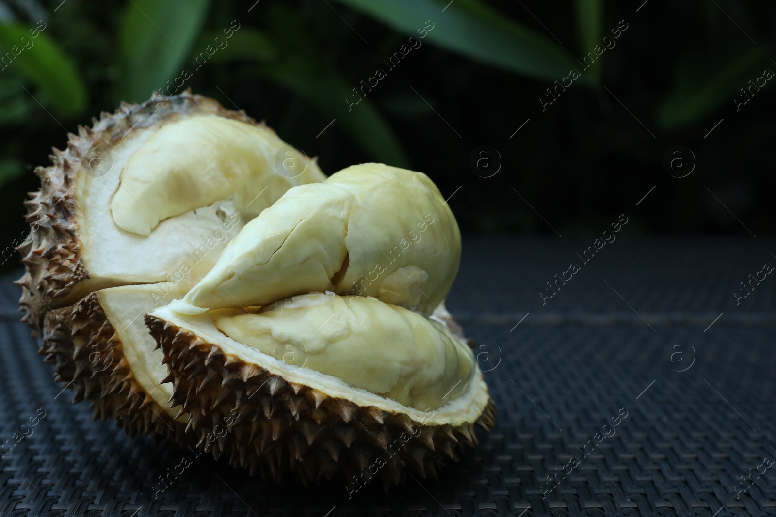 Fresh ripe durian on wicker table outdoors, closeup. Space for text Photo of Fresh ripe durian on wicker table outdoors, closeup. Space for text
