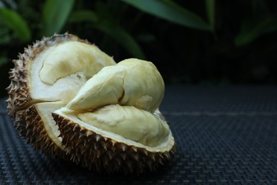 Photo of Fresh ripe durian on wicker table outdoors, closeup. Space for text