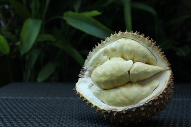 Photo of Fresh ripe durian on wicker table outdoors, closeup. Space for text
